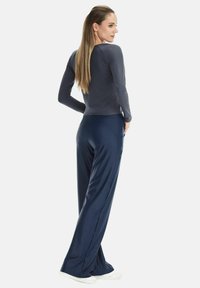 Navy blue long pants made from soft fabric paired with a fitted long-sleeve dark gray top, featuring a smooth texture and simple design.