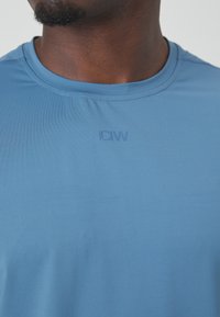 Μπλε αθλητικό μπλουζάκι κοντομάνικο από λείο ύφασμα. Διαθέτει στρογγυλή λαιμόκοψη και λογότυπο "ICIV" χαμηλού προφίλ στο στήθος.