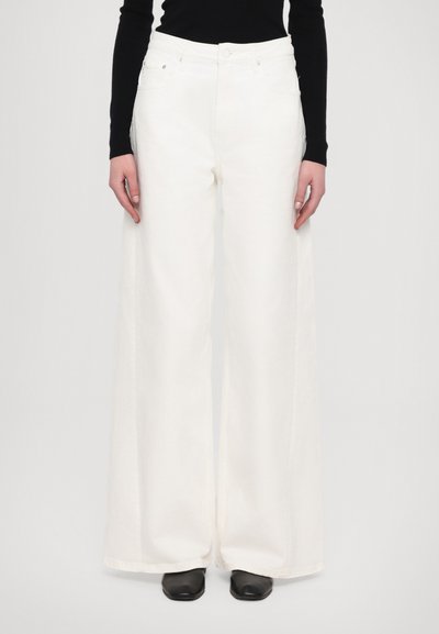 Jeans anchos blancos de mezclilla, con cintura alta, bolsillos frontales y un diseño clásico de cinco bolsillos. Textura suave y corte ajustado.