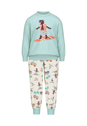 Un sweat-shirt bleu clair avec un graphique d'ours en maillot de bain, associé à un pantalon crème affichant un motif ludique de planches de surf et de palmiers.