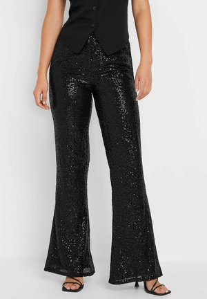 Zwarte pailletten flared broek met een gestructureerd oppervlak, met een hoge taille en een gladde afwerking, gecombineerd met strappy zwarte sandalen.