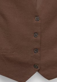 Gilet en tissu marron texturé avec quatre boutons ronds foncés et une petite poche horizontale sur le côté gauche.