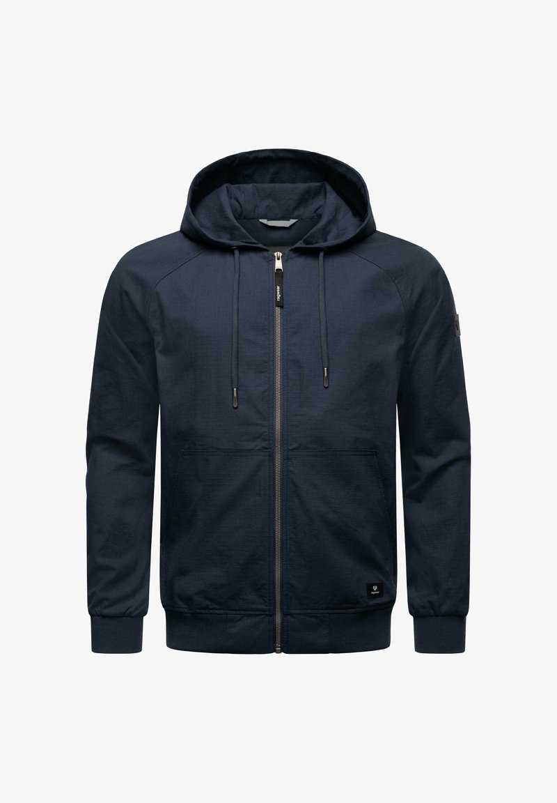 Mörkblå zip-up hoodie med huva, långa ärmar och framfickor. Har en texturerad tyg och en svart logotyp på den nedre vänstra sidan.