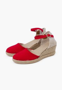 Sandalias de cuña de lona roja con una correa de tobillo de yute beige trenzado, suela de yute y diseño de punta redonda. Textura suave con una parte superior transpirable.