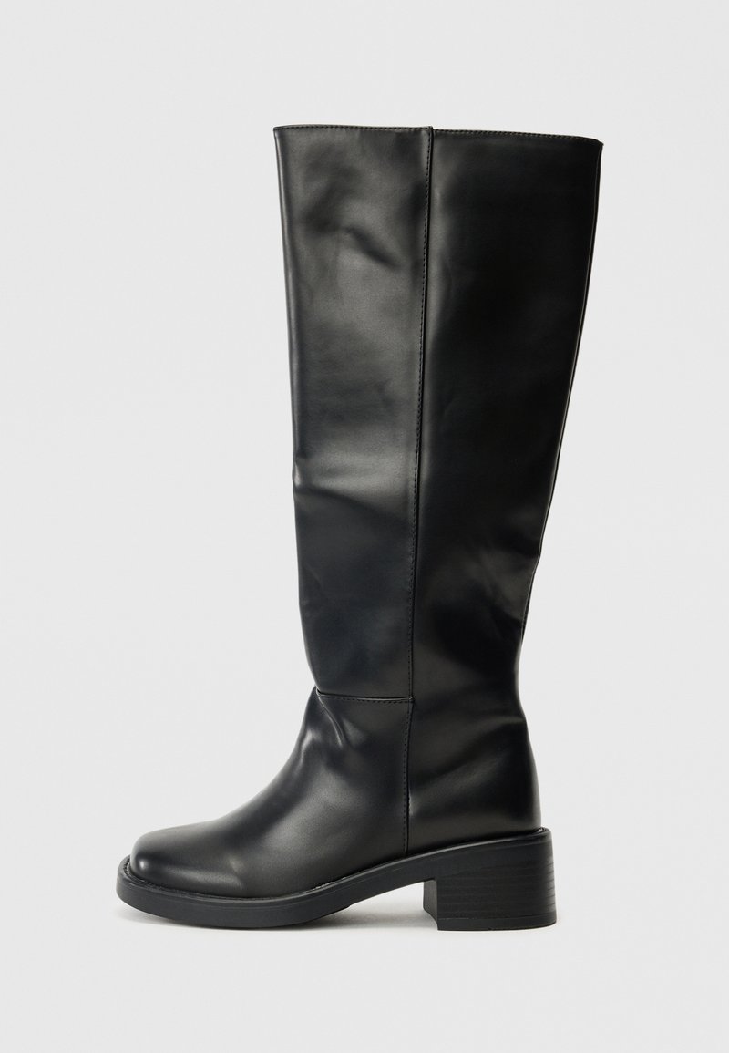 Bottes noires montantes en cuir lisse, avec un bout rond et un talon large, au design simple sans quincaillerie visible.