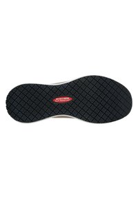 Semelle de chaussure noire en caoutchouc avec un motif texturé et une étiquette rouge "SKECHERS ANTIDÉRAPANT" au centre. Bord blanc autour de la semelle.