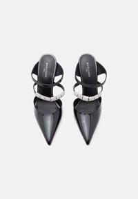 Μαύρες παπούτσια από πατεντέ δέρμα με μυτερή μύτη και διπλές λουρίδες, η μία διακοσμημένη με ρινοστόν, με την ετικέτα Marciano Guess μέσα.