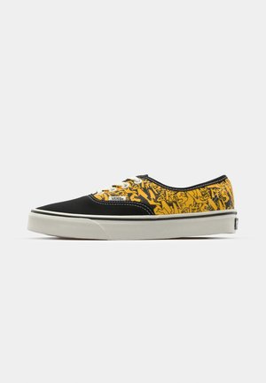 Schwarze Leinensneaker mit gelbem grafischem Muster, weißen Schnürsenkeln und Gummisohle. Verfügt über kontrastierende Nähte und ein strukturiertes Design.