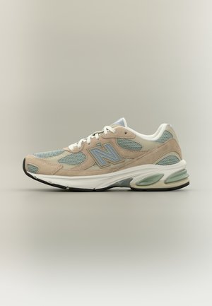 Beiger und hellgrüner sportlicher Sneaker mit weißen Schnürsenkeln, Mesh- und Wildledereinsätzen, gepolsterter Sohle und „N“-Logo an der Seite.