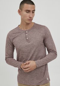 Langærmet henley-skjorte i støvet rosenfarve med en tekstureret stof, der har rund halsudskæring, tre knaplukninger og tætsiddende manchetter.