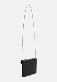 Borsa a pochette nera con tracolla a catena, caratterizzata da un bordo superiore testurizzato con un motivo decorativo e un corpo liscio e opaco.