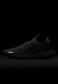Chaussure de course noire Nike avec dessus en maille, design à lacets, languettes de traction sur la languette et le talon, et un détail réfléchissant blanc près de l’orteil.