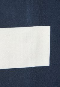 Cotton textile featuring a navy blue background with a sharp-edged, rectangular white patch in the center, textured weave, and solid colors.