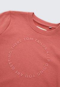 Zalmroze sweatshirt met een ronde hals, voorzien van reliëf rond tekst in een lichtere tint, gemaakt van zacht, gestructureerd stof.