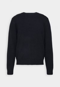 Pull noir en maille avec un col rond, des manches longues et un ourlet côtelé. La texture semble douce, avec un design simple et classique.