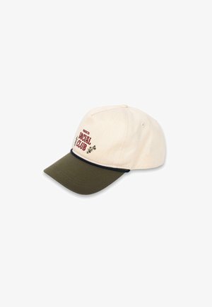 Gorra de béisbol de algodón con corona color crema, visor verde y texto bordado "Social Club" en rojo. Presenta una línea de acento oscura en el visor.
