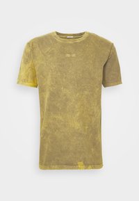 T-shirt en coton vert olive avec une texture lavée, manches courtes, encolure ronde et un petit logo en accent à l'avant.