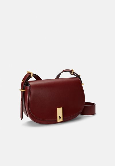 Bolsa a tiracolo em pele cor bordô com formato curvo, ferragens douradas e fecho plano com um logótipo. Alça ajustável anexada.