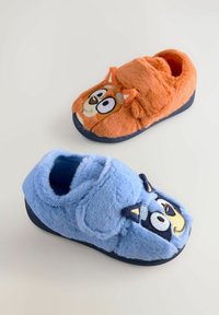 Chaussons en fausse fourrure orange et bleu. Chacun présente un visage d'animal de dessin animé, avec des oreilles et des détails brodés. Texture douce et forme arrondie.