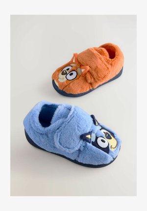Faux kožešinové pantofle v oranžové a modré barvě. Každé má na sobě obličej kreslené zvířátka, s ušima a vyšitými detaily. Měkká textura a zaoblený tvar.
