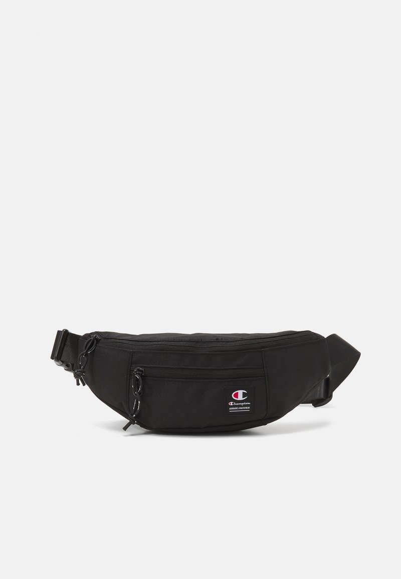 Marsupio nero realizzato in tessuto resistente, dotato di tasca frontale con zip, tracolla regolabile e una piccola patch con logo sul lato.