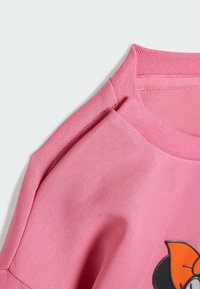 Rosa bomull t-shirt med rund halsringning, korta ärmar och en färgglad tecknad grafik på framsidan med en mjuk textur.