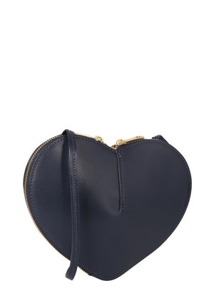 Navy blue heart-shaped leather wristlet with gold zipper and attached strap against a white background.