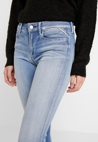 Jasnoniebieskie dżinsy o slim fit, z zapięciem na guzik i zamek błyskawiczny, kieszeniami bocznymi oraz metką z logo na pasku.