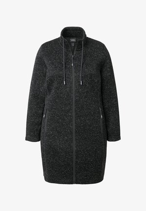 Lungo cappotto nero e grigio maculato con zip, colletto alto, coulisse e tasche laterali con zip, realizzato in tessuto a maglia.