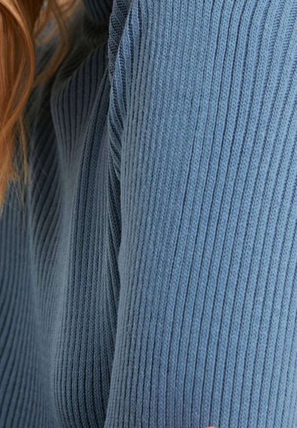 Niebieski sweter z ribbowanym splotem, charakteryzujący się teksturowanym wzorem i dopasowanym krojem, wykonany z miękkiego, elastycznego materiału.