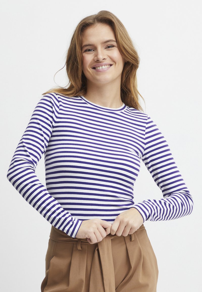 Langærmet top med vandrette hvide og lilla striber, rund halsudskæring, ribbet tekstur, tætsiddende design og en afslappet pasform.