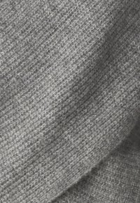 Tela entrelazada gris con un patrón texturizado sutil. El material parece suave y cálido, con un peso medio y un color uniforme en toda su superficie.