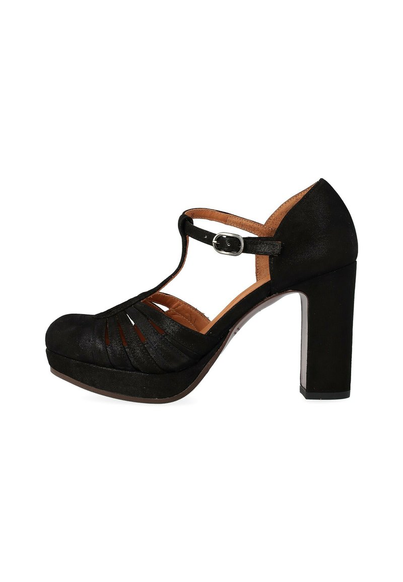 Scarpa nera con tacco alto, punta arrotondata, cinturino a T e design con ritagli. Presenta un tacco largo e un materiale superiore strutturato. Fibbia regolabile.