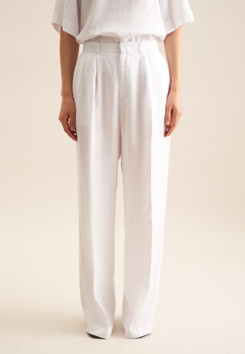 Witte linnen broek met een hoge taille, plooien en een losse, rechte pasvorm. Gladde textuur en minimalistische stijl.