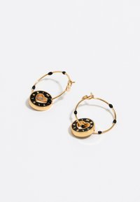 Pendientes de aro dorados con acentos negros, colgantes circulares con un anillo exterior negro y letras en relieve; acabado brillante y diseño ligero.