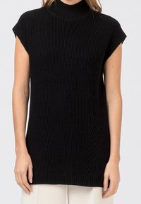 Musta ilmanhiha turtleneck, jossa on röyhelötekstuuri, suora leikkaus ja hienovarainen vinoraitapaneeli edessä.