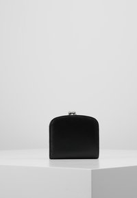 Portefeuille en cuir noir avec un dessus arrondi, fermeture à clip en argent, texture lisse et design minimaliste. Forme rectangulaire compacte.