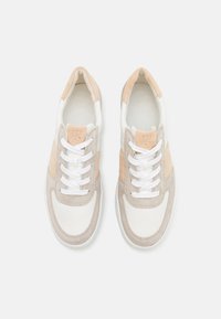 Baskets blanches avec des accents en daim beige et pêche, dotées d'un bout arrondi, de lacets blancs et d'un matériau supérieur texturé.