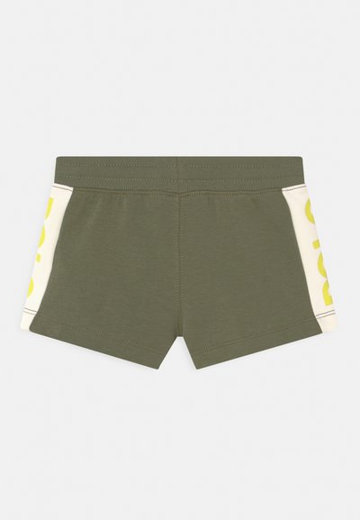 Calções de algodão verdes com um design ajustado. Apresentam painéis laterais de cor clara com lettering em amarelo forte. Detalhes de costura simples.