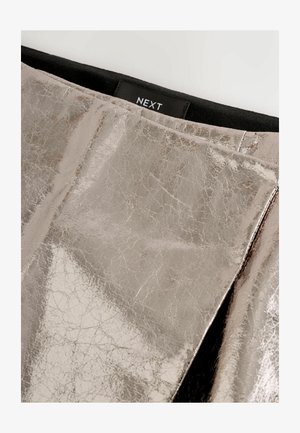 Hõbedane metalliktekstuuriga kude musta vöökoha ja väikese sildiga, millel on peal keskel sõna NEXT.