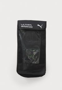 Svarta målvakts handskar förvarade i en genomskinlig påse, med texten 'ULTRA GOALKEEPER GLOVES' och en grön Puma-logotyp.