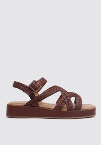 Sandales tressées marron avec une semelle intérieure rembourrée, une sangle de cheville réglable avec une boucle et une semelle épaisse.