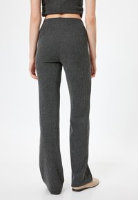 Grijze, gestructureerde flared broek met een hoge taille en subtiel streep patroon, met een gladde stofafwerking en een aansluitende silhoutet.