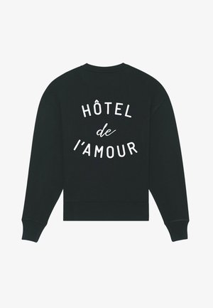 Černá mikina s bílým nápisem "HÔTEL de l'AMOUR" vytištěným na zadní straně zakřivenými liniemi, obsahující dlouhé rukávy a žebrované manžety a spodní lem.