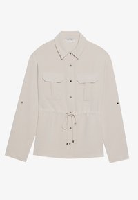 Lichtbeige blouse met lange mouwen en een kraag met knopen, twee voorzakken, een trekkoord in de taille en zilveren drukknoopjes. Gladde, gestructureerde stof.