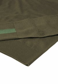 Olijfgroen gebreid sweater met ribgebreide manchetten en onderrand, evenals een klein logo-detail. Zachte textuur met een contrasterende groene streep.