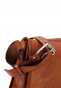 Borsa in pelle marrone con finitura testurizzata, dotata di fibbia metallica, dettagli cuciti e manico in pelle arrotolata per una presa sicura.