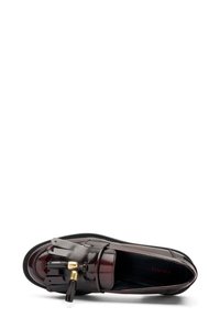 Mocasines de cuero en un profundo burdeos con un acabado brillante, que presentan un detalle de flecos en la parte delantera y acentos de hardware en tono dorado.