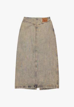 Denim midi-kjol med rak passform, ljusblå färg och synlig sömnad. Har en brun läderlapp på midjebandet.