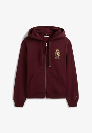 Burgundy zip-up hoodie made of cotton blend, featuring a kangaroo pocket, drawstring hood, and gold lion emblem with crown.